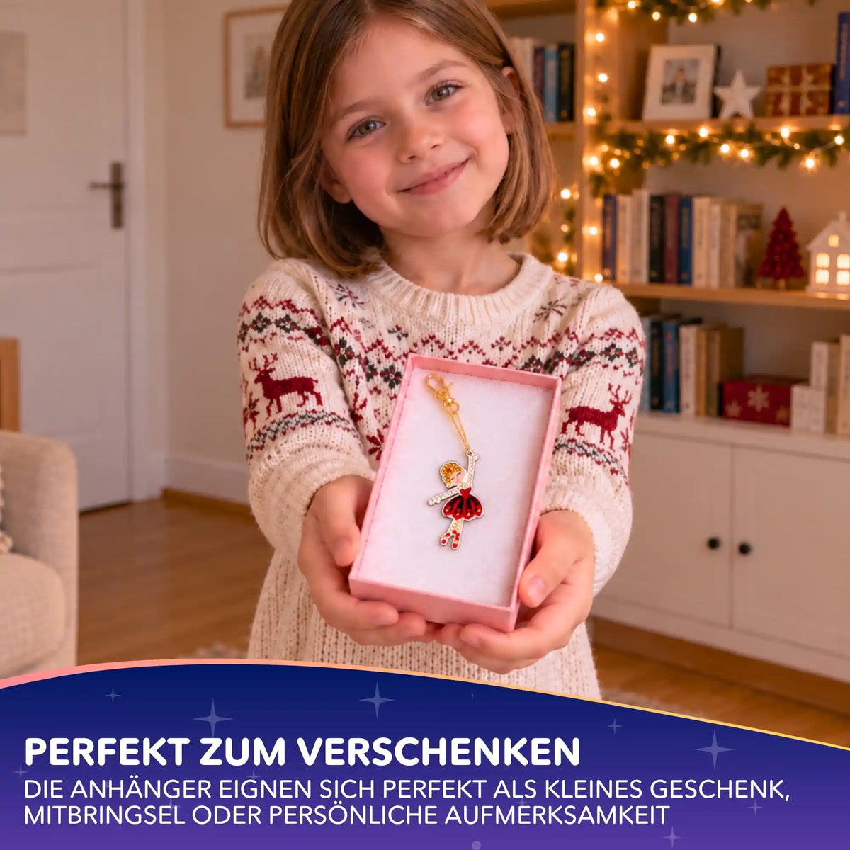Mädchen hält Geschenkbox mit funkelndem Diamond Painting Schlüsselanhänger Ballerina aus dem Nussknacker Set.