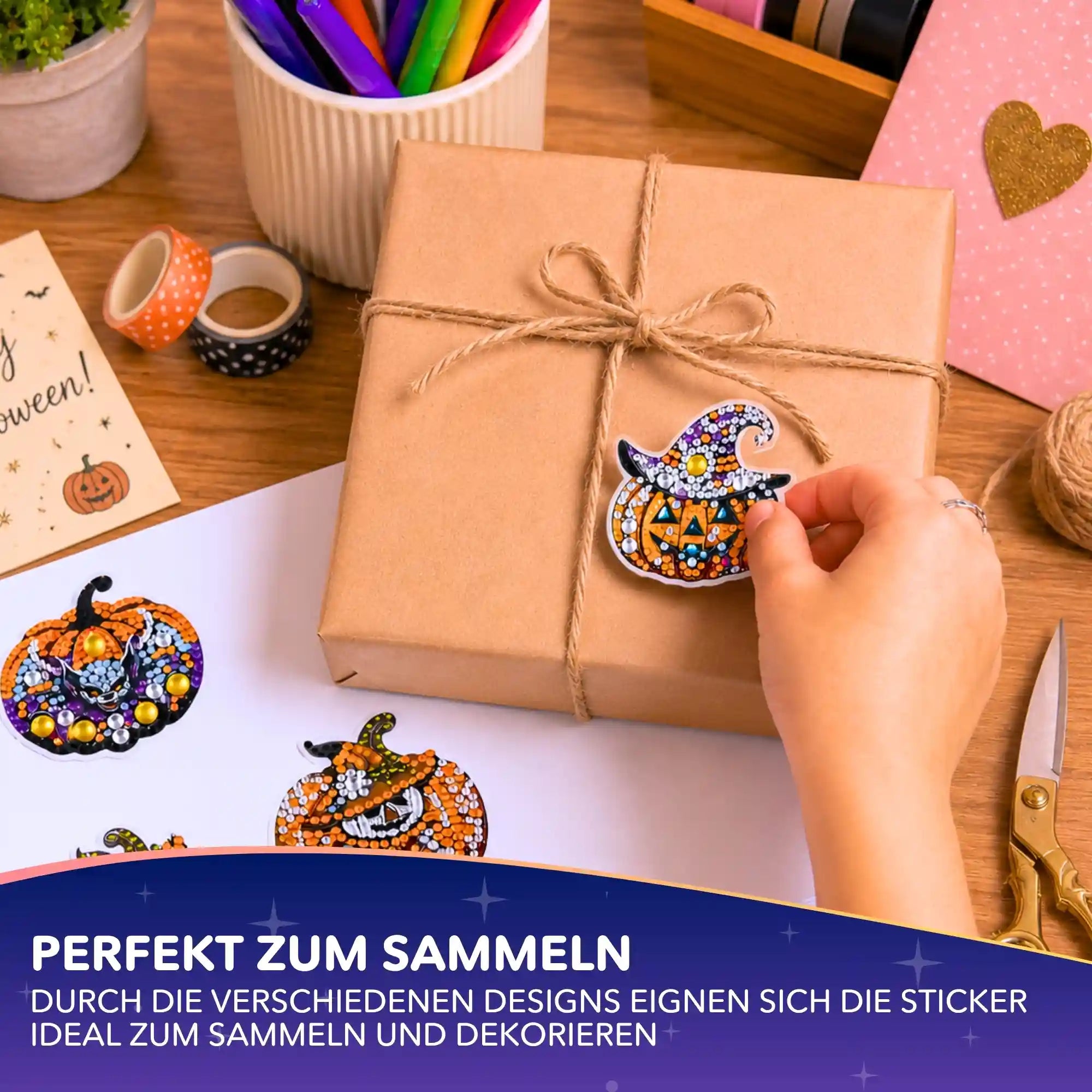 Hand klebt funkelnden Halloween-Kürbis-Sticker aus einem Diamond Painting Set auf ein Geschenkpaket